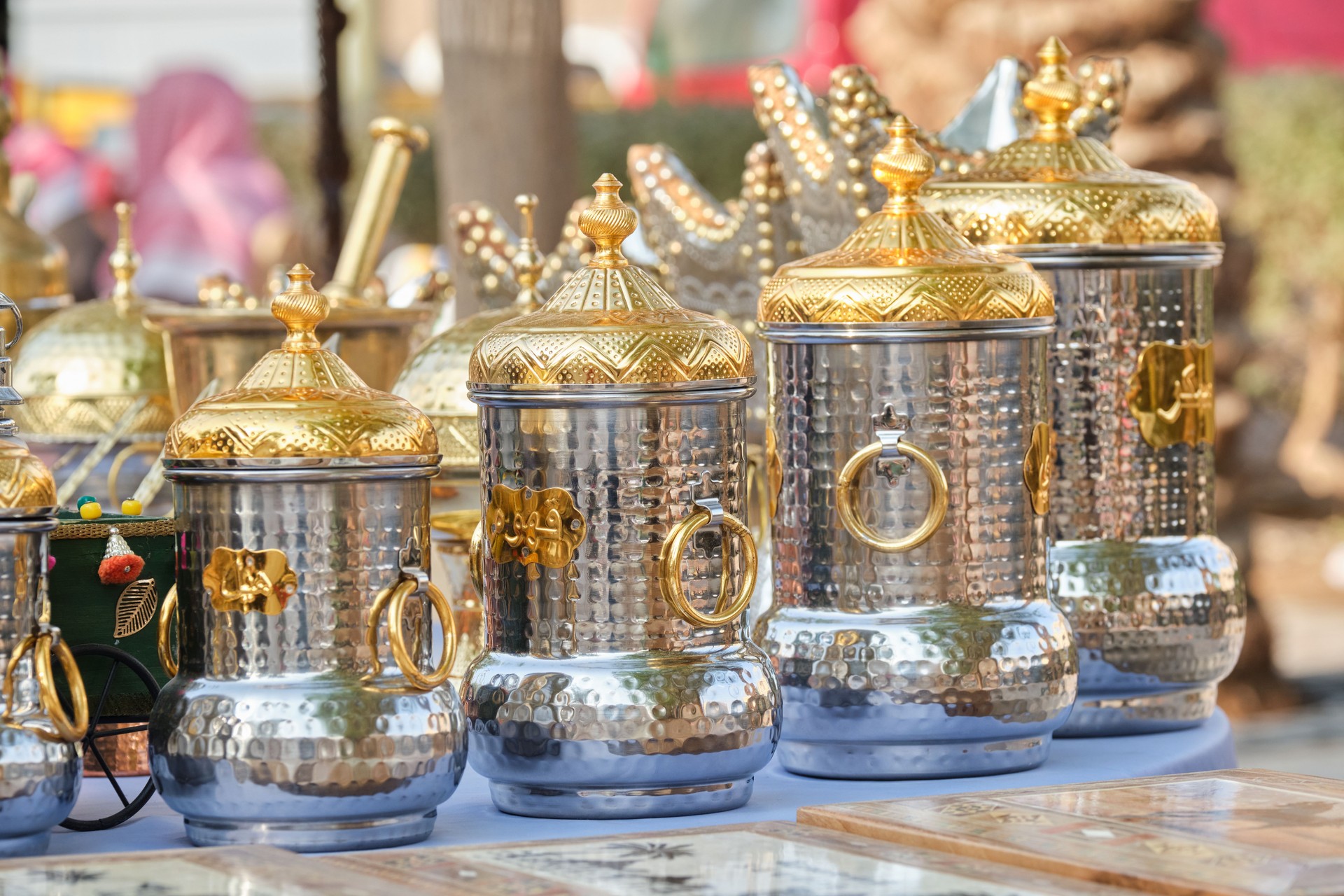 Decorative Hammered Metal Jars with Ornate Golden Lids on Display